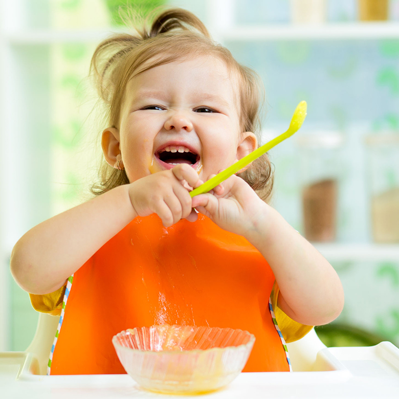 31913675 – funny baby eating healthy food on kitchen